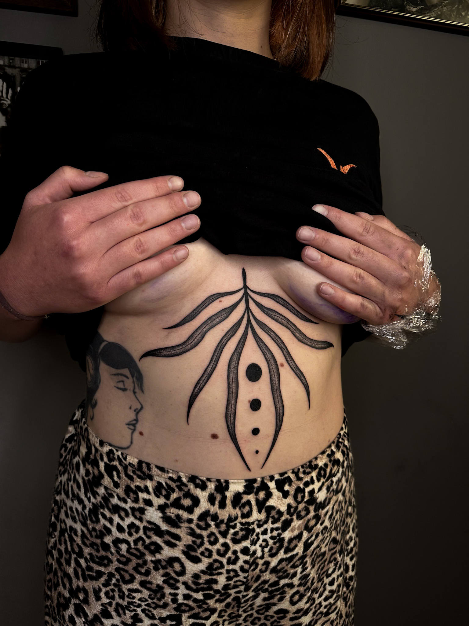 Bold black leaf fronds and dots under the chest
